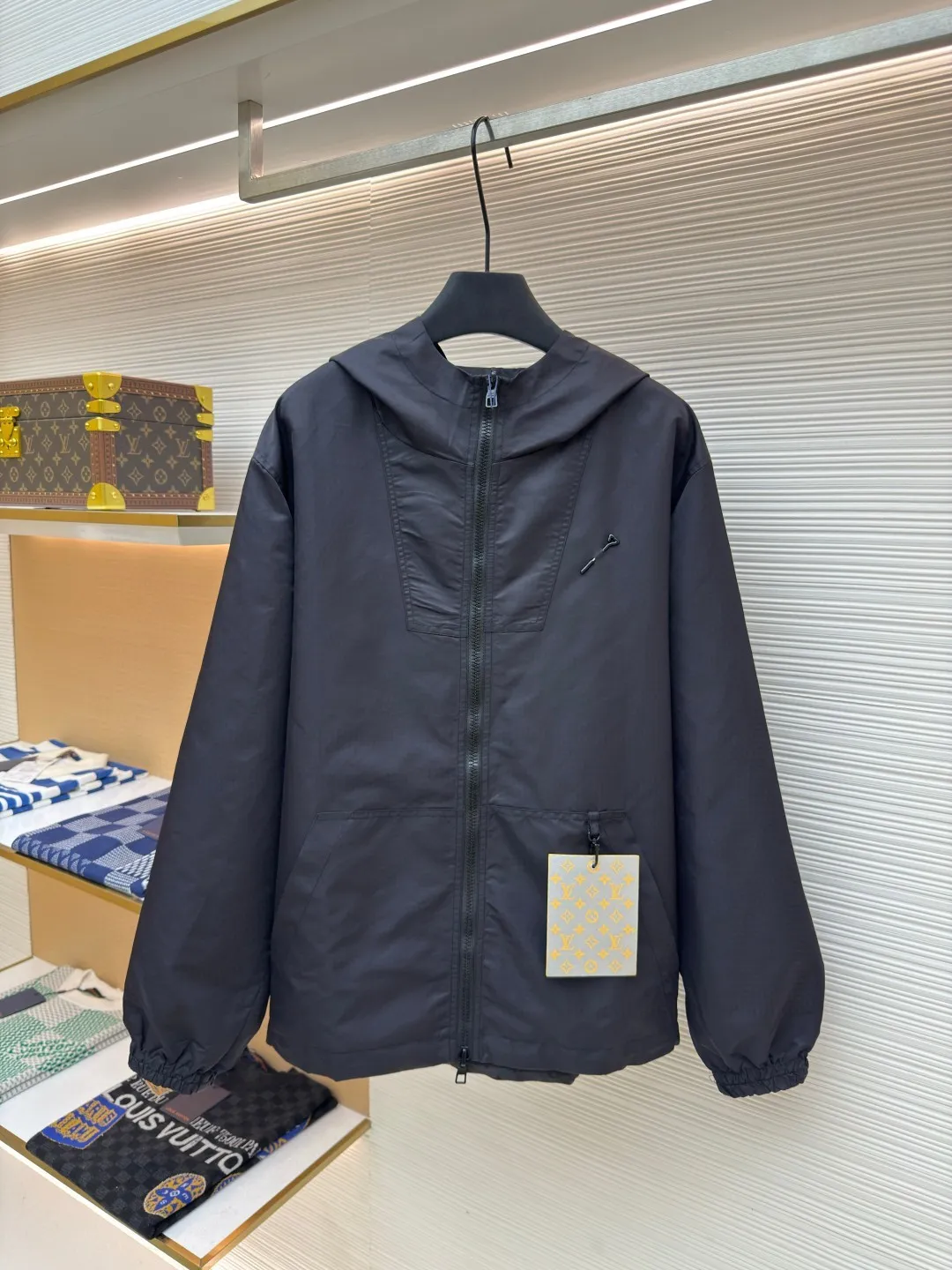 LOUIS VUITTON double-sided windproof pin jacket ●Authentic product: purchased and developed for 22800 ●Item number: 1680472-C55 ●Fabric: polyester fiber fabric ●Technology: jacquard ●Version: fitted version ●Weight: about 565 grams ●Size: 44-46-48-50 ●Description: The solid color fabric is made of nylon encrypted matt twill fabric, and the jacquard fabric on the other side is made of 50D nylon yarn-dyed jacquard fabric. The solid color front panel is laser-burned, hand-made of white copper, with a triangle pin with logo and glossy finish. The front panel pocket uses a hardware keychain to hang a folding clothing tag, and the jacquard letters on the front chest placket are made of single-piece flowing pure It is cut by hand to restore the flower, and all the pieces are numbered. The pockets are also cut with the restored flower number. The fabric is relatively light and silky, and it takes time to cut accurately. The front and center are equipped with a double-circulation puller 5# orbital zipper. The hem and the hood are worn with spiral elastic ropes with ring anti-slip buckles, square pig nose buckles with logo, and all holes are punched with hardware and logo on the cloth-colored cornrows.
